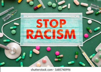 Stop Racism, Disease Infection Concept. Stop Racism Text On A Medical Mask, Medicine Health Green Background. No To Racism, Social Exclusion Message Flat Lay