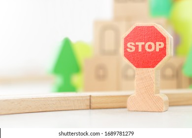 Stop Road Sign On The Background Of The Children's Kit Of A Wooden Toy City. Railway In The Children's Room. Teaching Children The Rules Of The Road, Child Safety Concept, Selective Focus