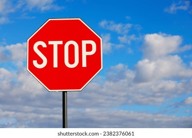 Stop Sign Against Blue Sky and Clouds