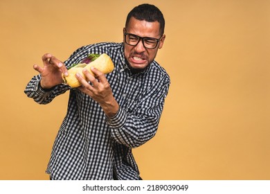 Stop Sign, Bad Smell. Young African American Black Man Eating Sandwich Isolated Over Beige Background. Diet Concept.