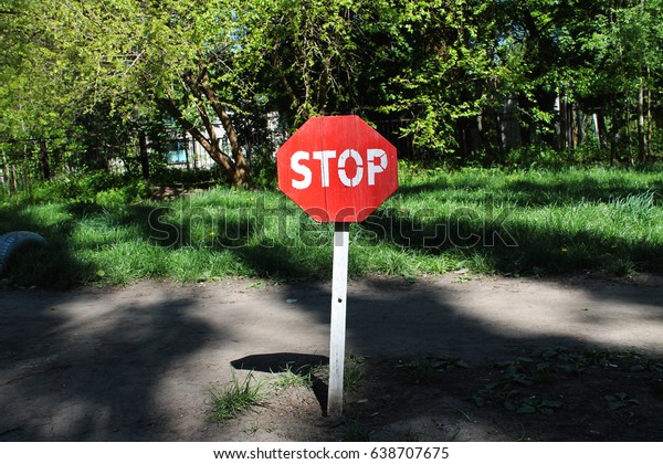 Stop sign close-up on a wooden pole. Protected\
area. Stop it. Attention.