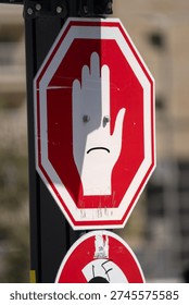 A stop sign featuring two bolt “eyes” and a scribbled mouth, giving it a cartoon‑like expression.