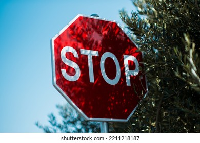 Stop Sign Next To Tree Leaves.