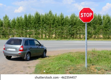 Stop Sign On The Road And A Car