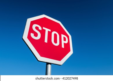 Stop Sign In Perspective View Against Blue Sky