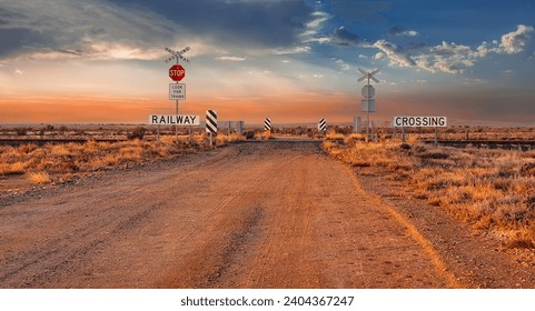 Stop sign at a railway crossing in the outback of South Australia. sign saying look out for trains. Sunrise - Powered by Shutterstock