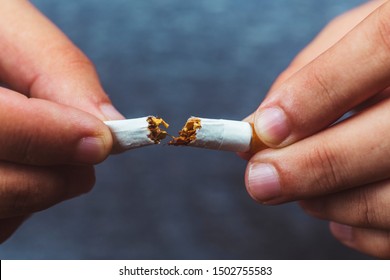Stop smoking. Adult man breaking cigarette - Man Presenting Anti Tobacco Campaign Showing and Breaking a Cigarette in Hands