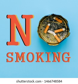 Stop Smoking. Ashtray With Cigarette Butts And Ash On A Blue Background. The Concept Of Life Without Tobacco. No Smoking Sign. Bad Habits, Medications And Health Care.