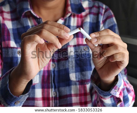 Stop smoking cigarettes concept. Portrait of woman holding broken cigarette in hands.woman quitting smoking cigarettes. Quit bad habit, health care concept. No smoking.