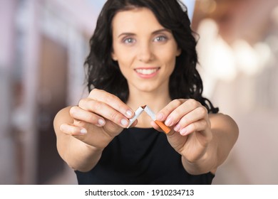 Stop Smoking Cigarettes Concept. Young Smiling Girl Holds A Broken Cigarette In Hands.