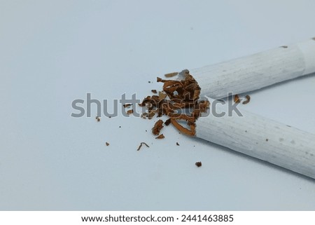 Stop Smoking Concept. Close-up portrait of a broken cigarette crossed against on a clean with isolated background. 