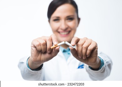 Stop smoking concept with female doctor breaking a cigarette. - Powered by Shutterstock