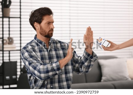 Stop smoking concept. Man refusing cigarettes indoors