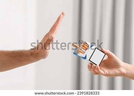 Stop smoking concept. Man refusing cigarettes on blurred background, closeup