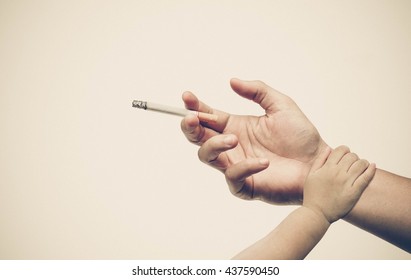 Stop Smoking. Hand Of A Baby Touching Hand Of A Father With A Cigarette. Dad Stop Smoking Concept. World No Tobacco Day