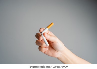 Dejar de fumar, dejar de fumar o no fumar cigarrillos. Mujer sosteniendo un cigarrillo roto en las manos. La mujer rechaza los cigarrillos y el concepto de salud pulmonar.
