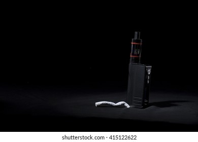 Stop Smoking, Start Vaping. A Vape Or Electronic Cigarette And A Cigarette Shot On A Black Background  With Space For Text On The Left.