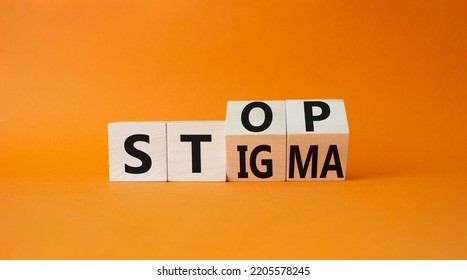 Stop and Stigma symbol. Businessman hand points at wooden cubes with words Stop and Stigma. Beautiful orange background. Business and Stop and Stigma concept. Copy space.