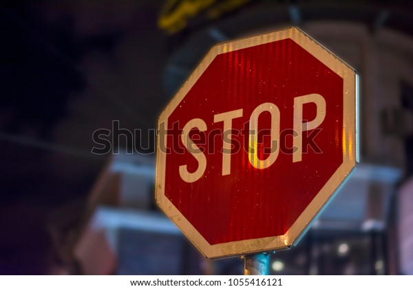 Stop street\
night sign STOP on rod in the\
city