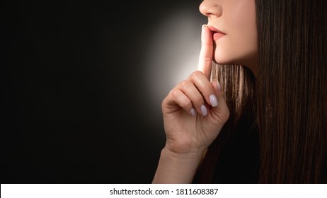 Stop talking. Domestic violence. Mysterious woman asking to keep quiet with finger on lips isolated on black empty space background. Betrayal gossip. Whistleblower secret. Social problem.