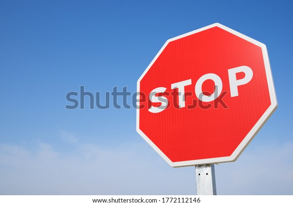 Stop traffic sign with\
clear blue sky.