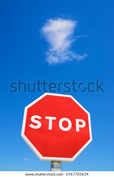 Stop traffic sign with\
clear blue sky.