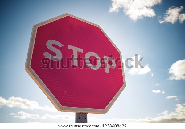 Stop traffic sign with\
cloudy sky.