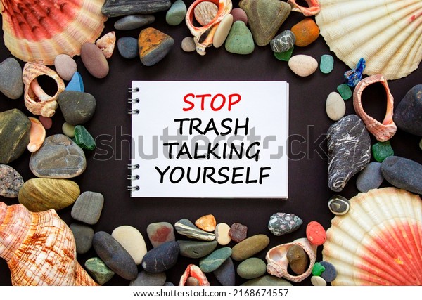 Stop trash talking yourself symbol. Concept words\
Stop trash talking yourself on a beautiful black background. Sea\
stones and seashells. Psychological stop trash talking yourself\
concept. Copy space.