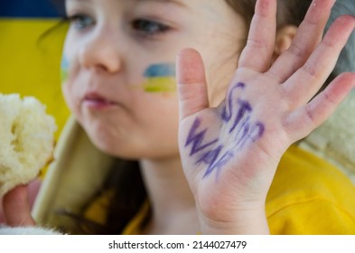 Stop the war in the palm of your hand. Stop war on a child's palm. Children against war. War in Ukraine. Child safety. Ukrainian refugees. Civilians of Ukraine. Ukrainian children. Peace concept.
