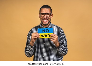 Stop war! Save Ukraine! Portrait of sad negative african american black guy holding ukrainian flag, isolated over beige background. - Powered by Shutterstock