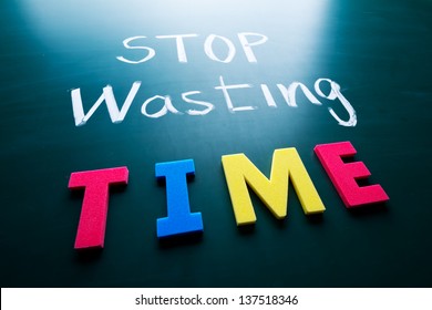Stop wasting time concept  colorful words blackboard
