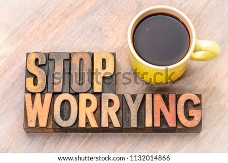 stop worrying- word abstract in vintage letterpress wood type with a cup of coffee