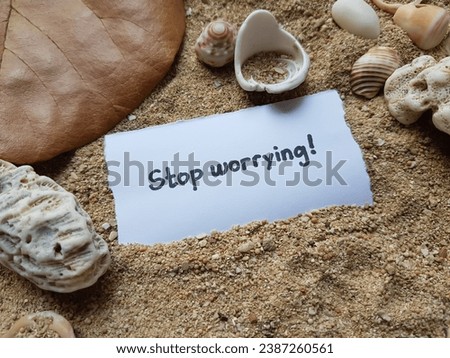 Stop worrying written on beach sand background.