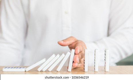 Stopping domino effect concept for business solution strategy, financial or investment protection and successful intervention with corporate person's hand blocking the collapse disruption