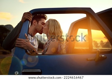 Stopping for a smooch. Shot of an affectionate young couple on a roadtrip.