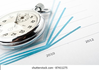 stopwatch and financial growth chart on the table in the office