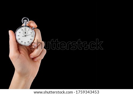 stopwatch hold in hand, button pressed, monochromatic black back ground