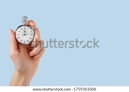 stopwatch hold in hand, button pressed,monochromatic light blue  background