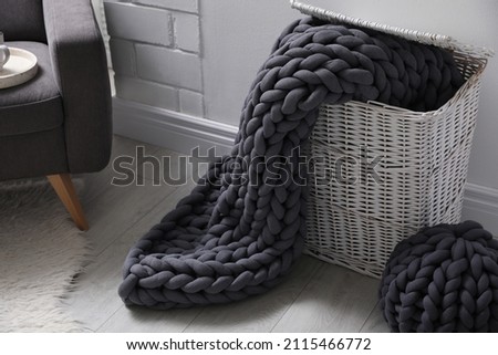 Storage basket with soft chunky knit blanket in room