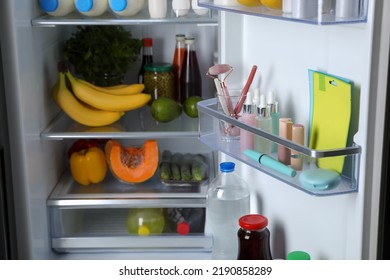 Storage Of Cosmetics And Tools In Refrigerator Door Bin Next To Groceries