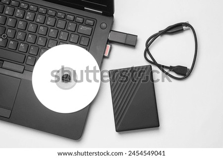 Storage media. Laptop with CD disk, sd card, USB flash drive and external hard drive on white background.