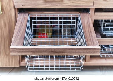 Storage organization. Metal mesh basket in wooden drawer in food storage room. Close-up - Shutterstock ID 1764010532