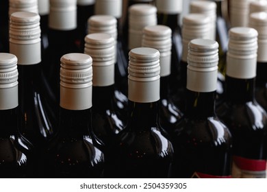 Storage of quality wine bottles with screw caps in a wine rack Close up of metal caps on dark glass wine bottles  - Powered by Shutterstock