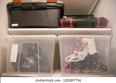 Storage Of Things On A Wooden Rack. A White Box And A Green Tool Box On A Wooden Shelf. A Pile Of Boxes In The Closet.