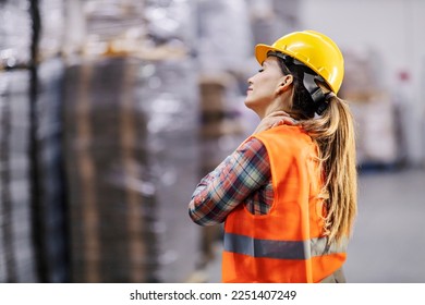 A storage worker is having a neck ache and rubbing it. - Powered by Shutterstock