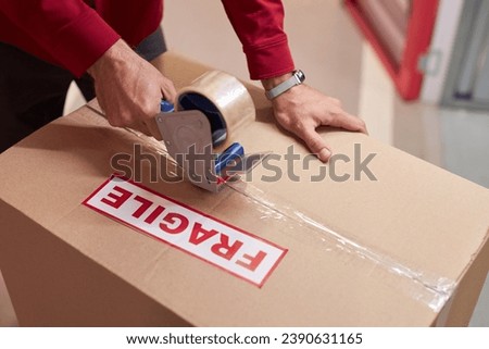 Storage Worker Taping Boxes in Warehouse