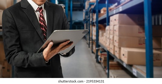 Storage worker in uniform Wearing Hard Hat Checks Stock and Inventory with Digital Tablet Computer in the Retail Warehouse full  - Shutterstock ID 2195334131