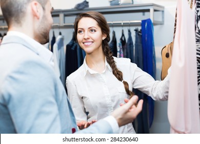 Store Clerk Serving Cheerful Purchaser At Fashionable Apparel Store