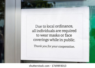 Store entrance exterior in Virginia with closeup of sign for all individuals customers required to wear face mask covering in public due to local ordinance - Shutterstock ID 1769893013