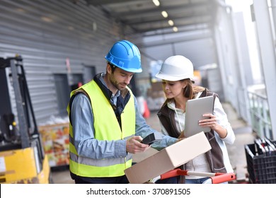 Store manager with warehouseman checking goods reception 